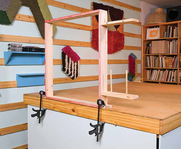 Finished DIY tabletop tufting frame clamped to a worktable