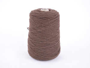 A large cone spool of brown yarn or thread, wound tightly on a light-colored plastic core, set against a plain white background.